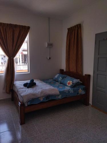 Un dormitorio con una cama con un osito de peluche. en ROOM STAy TOK WAN 2, en Kampung Kuala Besut