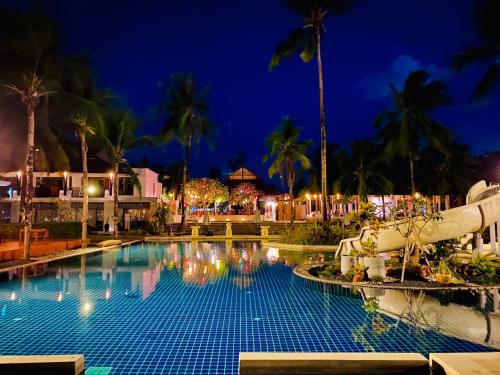 a pool at the resort at night at Palm Galleria Resort in Khao Lak