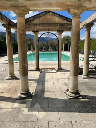 un pavillon avec une piscine dans un parc dans l'établissement La Mascotte des thermes de Montbrun les bains, à Montbrun-les-Bains