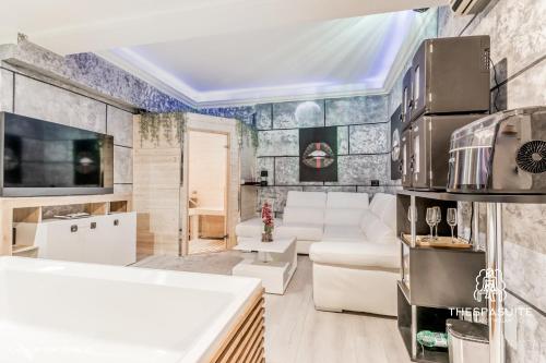 sala de estar con muebles blancos y TV en THESPASUITE Suite e Spa privata per coppie en Roma