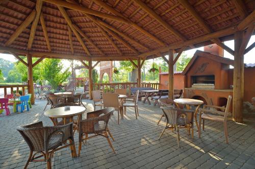 an outdoor patio with tables and chairs and a grill at Kasztelan in Krosno