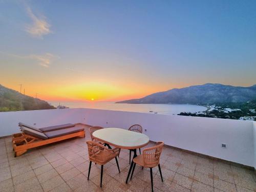 a patio with a table and chairs and a sunset at THALASSA in Livadia