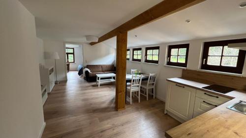 eine Küche und ein Wohnzimmer mit einem Tisch und einem Sofa in der Unterkunft Rauschenbachmühle in Mildenau