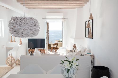 una sala de estar con muebles blancos y vistas al océano. en Villa Mandala en Mykonos