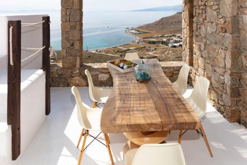 stół i krzesła na balkonie z widokiem na ocean w obiekcie Villa Mandala w mieście Mykonos