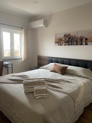 a bedroom with a bed with two towels on it at Apartamentos Barbosa in Vila Nova de Foz Coa