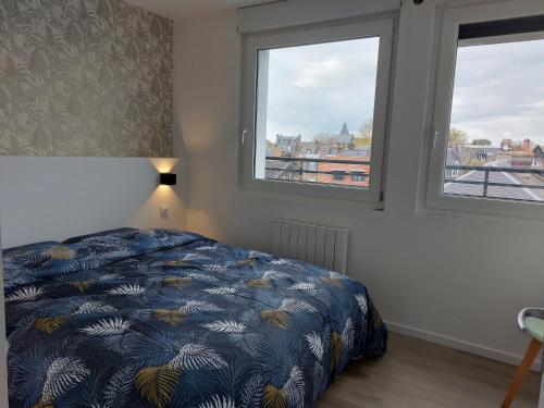 une chambre avec un lit et deux fenêtres dans l'établissement Sur les toits de Dieppe, à Dieppe
