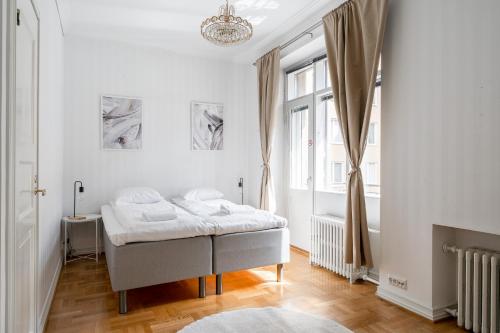 a white bedroom with a bed and a window at "Tuulensuu" - Historical 2BR Apartment with Sauna & Great Location, Hosted by 2ndhomes in Tampere
