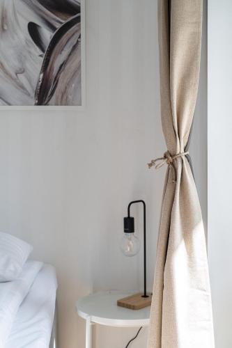 a bedroom with a bed and a table with a lamp at "Tuulensuu" - Historical 2BR Apartment with Sauna & Great Location, Hosted by 2ndhomes in Tampere