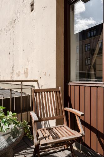 a wooden chair sitting on a porch with a window at "Tuulensuu" - Historical 2BR Apartment with Sauna & Great Location, Hosted by 2ndhomes in Tampere
