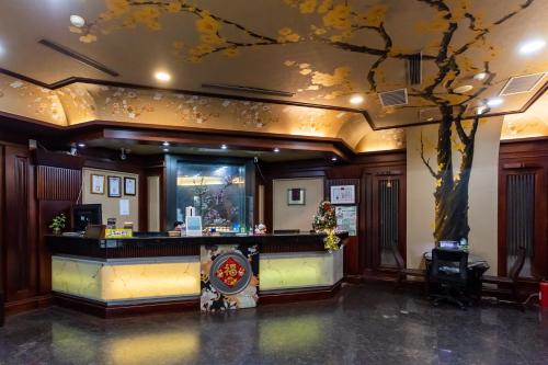 a hotel lobby with a tree painted on the ceiling at I HI Sanduo Travel Hotel in Kaohsiung