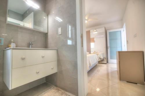 a bathroom with a sink and a mirror at Seaside apartment in the heart of Xlendi Gozo in Xlendi