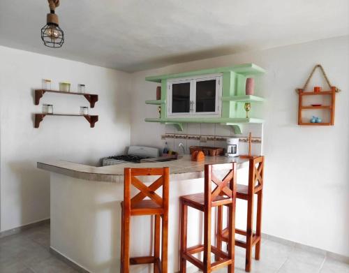 eine Küche mit einer Theke und Hockern in einem Zimmer in der Unterkunft Bay View Apt Quiet Area Weeklymonthly Discount in Santa Bárbara de Samaná