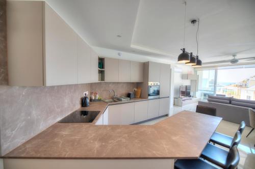 a kitchen with a counter top and a table and chairs at Seaside apartment in the heart of Xlendi Gozo in Xlendi