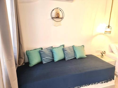 a room with a couch with blue pillows at Joannes Vacation Rooms in Adamantas