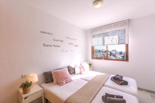 two beds in a room with words on the wall at Andaluz Apartments Mar de Nerja in Nerja