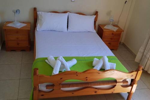 1 dormitorio con cama de madera y toallas en 'Magic Of Nature' Cottage With a Breathtaking View, en Dhriópi