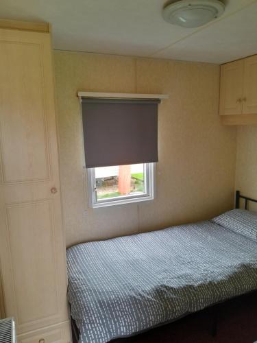 a bedroom with two beds and a window at Mablethorpe L17 Caravan in Mablethorpe