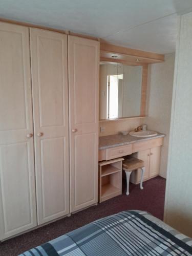 a bathroom with a sink and a vanity with a mirror at Mablethorpe L17 Caravan in Mablethorpe