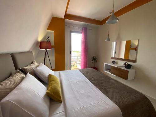 a bedroom with a bed with white and yellow pillows at Your Apartment in Pogradec