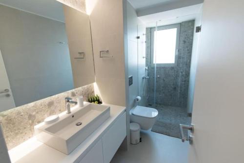 ein weißes Bad mit einem Waschbecken und einem WC in der Unterkunft Bright apartment in the New building (FORM_F1) in Athen