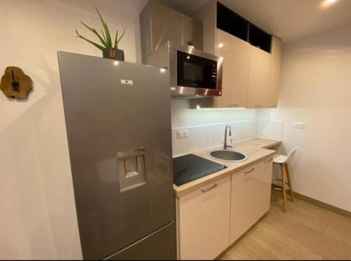 a small kitchen with a sink and a refrigerator at Appartement avec terrasse in Quimper