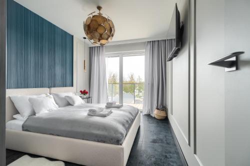 - une chambre avec un lit et une grande fenêtre dans l'établissement Bridge Apartments & Spa Dziwnów, à Dziwnów