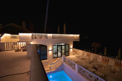 una casa con piscina por la noche en Hotel Vila Hedonija, en Herceg-Novi