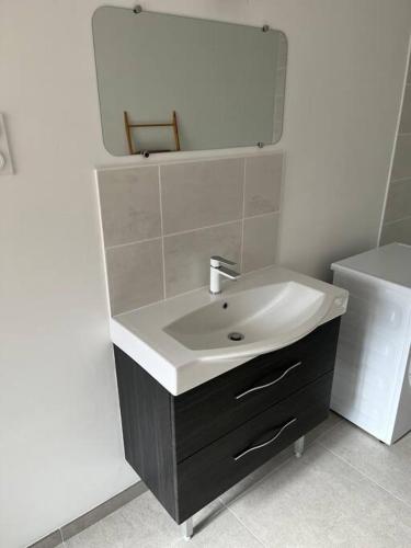 une salle de bain avec un lavabo et un miroir dans l'établissement Ker Joseph : longère bretonne rénovée, à Gommenec'h
