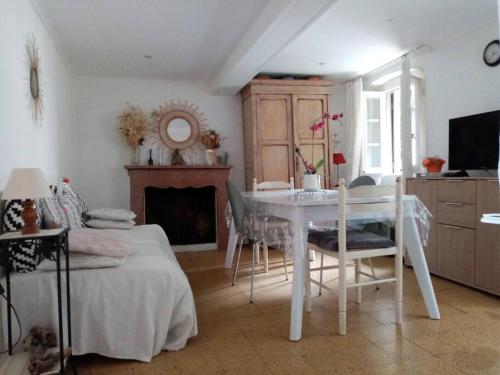 une salle à manger blanche avec une table et une cheminée dans l'établissement Maison atypique corse, à Bastia