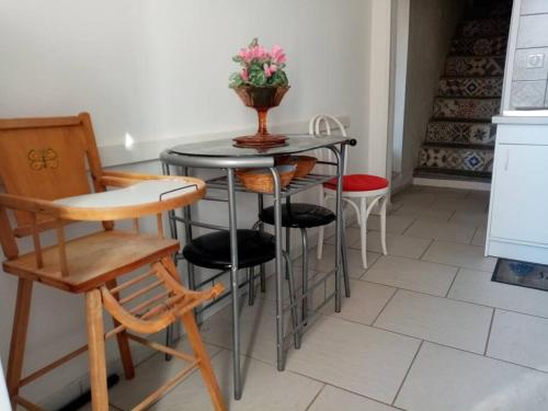 een tafel met stoelen en een vaas met bloemen erop bij Maison atypique corse in Bastia