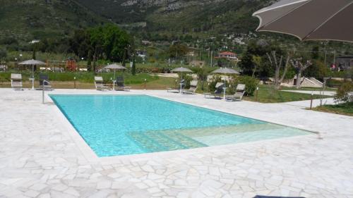 una piscina con sillas y sombrilla en Il Sentiero di Leano en Terracina