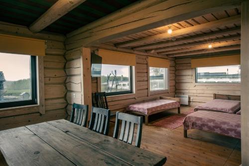 una habitación con mesa y sillas en una cabaña en Kotkapesa, 