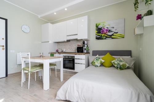 ein Schlafzimmer mit einem Bett und einem Tisch sowie eine Küche in der Unterkunft [Monza-Station] Wi-Fi e Smart-TV. in Monza