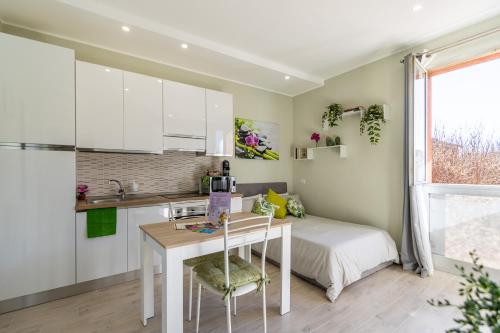 1 dormitorio con cama, escritorio y cocina en [Monza-Station] Wi-Fi e Smart-TV., en Monza