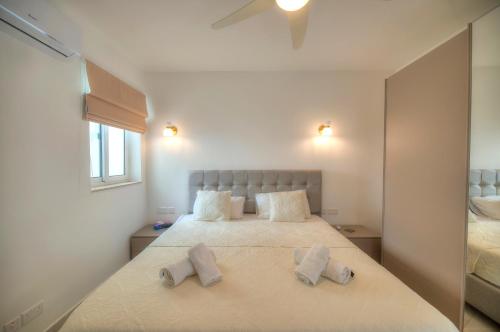 a bedroom with a bed with two pillows on it at Seaside apartment in the heart of Xlendi Gozo in Xlendi