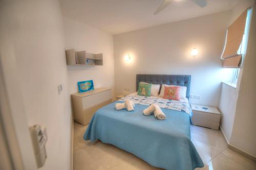 a bedroom with a bed with two towels on it at Seaside apartment in the heart of Xlendi Gozo in Xlendi