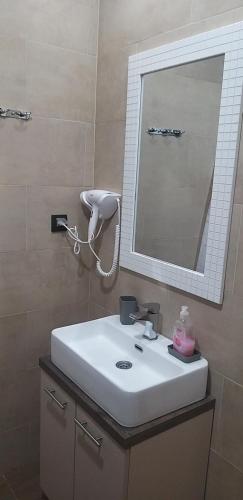 a bathroom with a white sink and a mirror at Ogy's apartment in Kopaonik