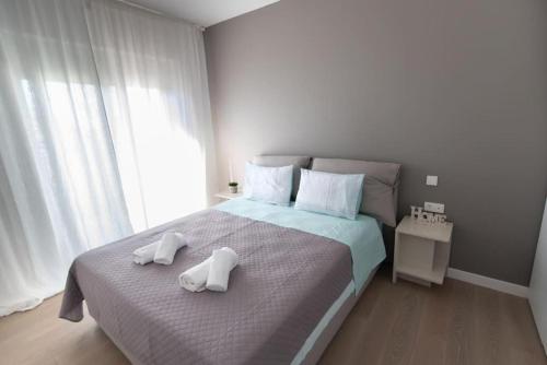 um quarto com uma cama grande e toalhas em Bright apartment in the New building (FORM_F1) em Atenas