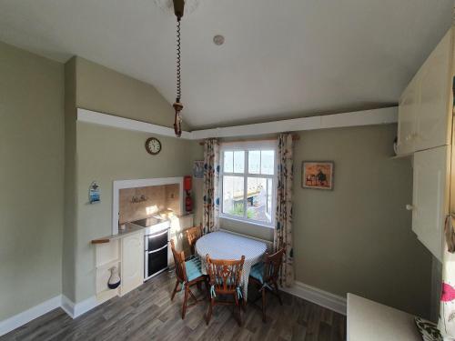 a kitchen with a table and chairs and a window at Hillside in Ardmore