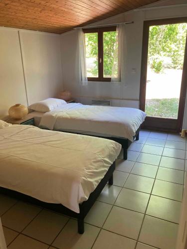 une chambre avec deux lits et une fenêtre dans l'établissement Résidence les chênes, à Parisot