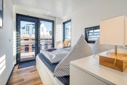 een slaapkamer met een bed en een bureau met een lamp bij Chalet am Meer in Peenemünde