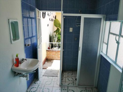 a blue bathroom with a sink and a shower at Excelente para Grupos! 5 min al centro, sólo 2.7km in Puebla