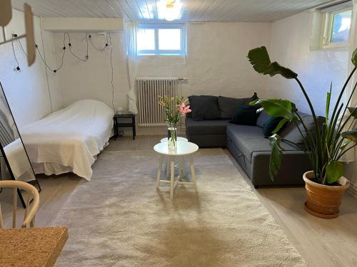 a living room with a couch and a table with flowers at Central living with many beds and private garden! in Gothenburg