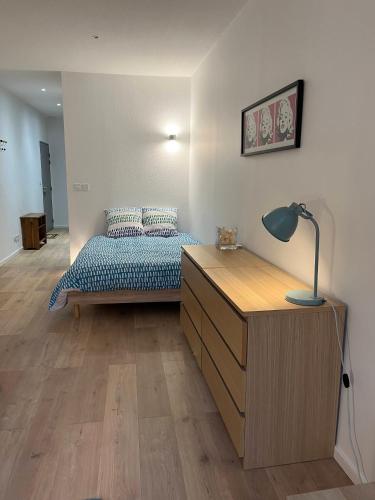 une chambre avec un lit et un bureau avec une lampe dans l'établissement Studio Lyon 6e proche metro et parc, à Lyon