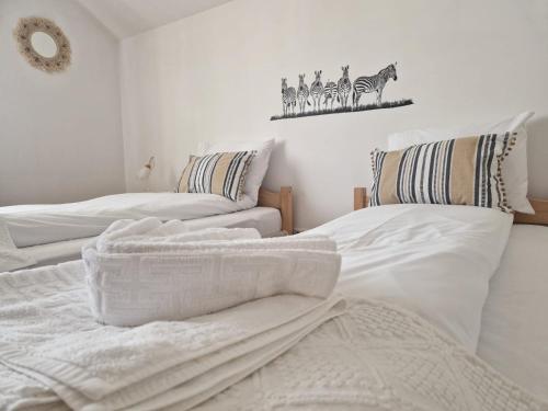 Duas camas brancas com toalhas num quarto em Celeste House Sibiu em Sibiu