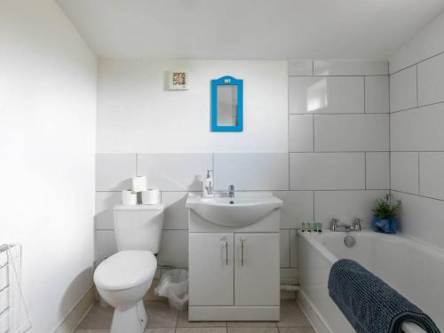 a bathroom with a toilet and a sink and a tub at Cute and Cosy 2 Bed on a Peaceful street in Kent
