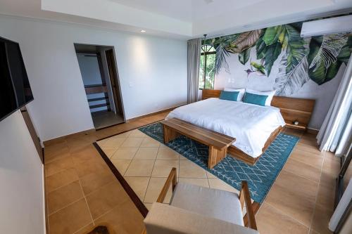 a bedroom with a king sized bed and a table at Marala Hotel in Esterillos
