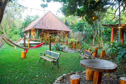 a garden with a hammock and a gazebo at Naturalmente Boutique Bungalows y Cocina Mediterránea in Las Lajas
