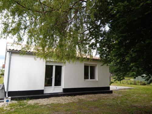 a small white house with a tree at Makivka - A 5 min de Cognac - Maison entière avec 2 chambres in Boutiers-Saint-Trojan